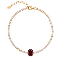 Gold tennis bracelet with oval ruby gemstone center and pavé-style stones