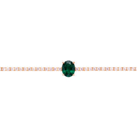 Gold tennis bracelet with oval emerald center stone