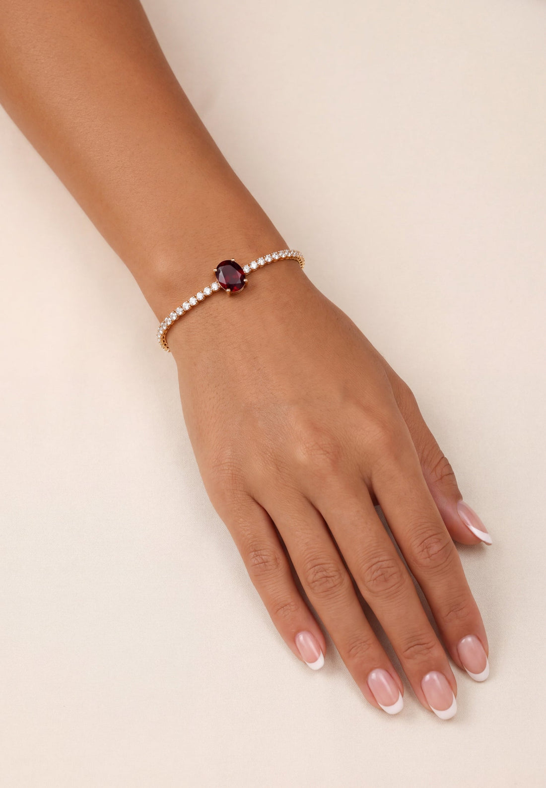Ruby oval gemstone tennis bracelet in gold on a model&