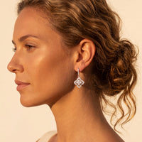 Silver CZ clover flower drop earrings on model, small dangling flower design