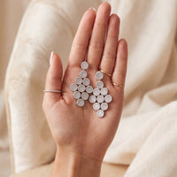 Silver disc cascading drop earrings shown in hand, with stacked circular drops