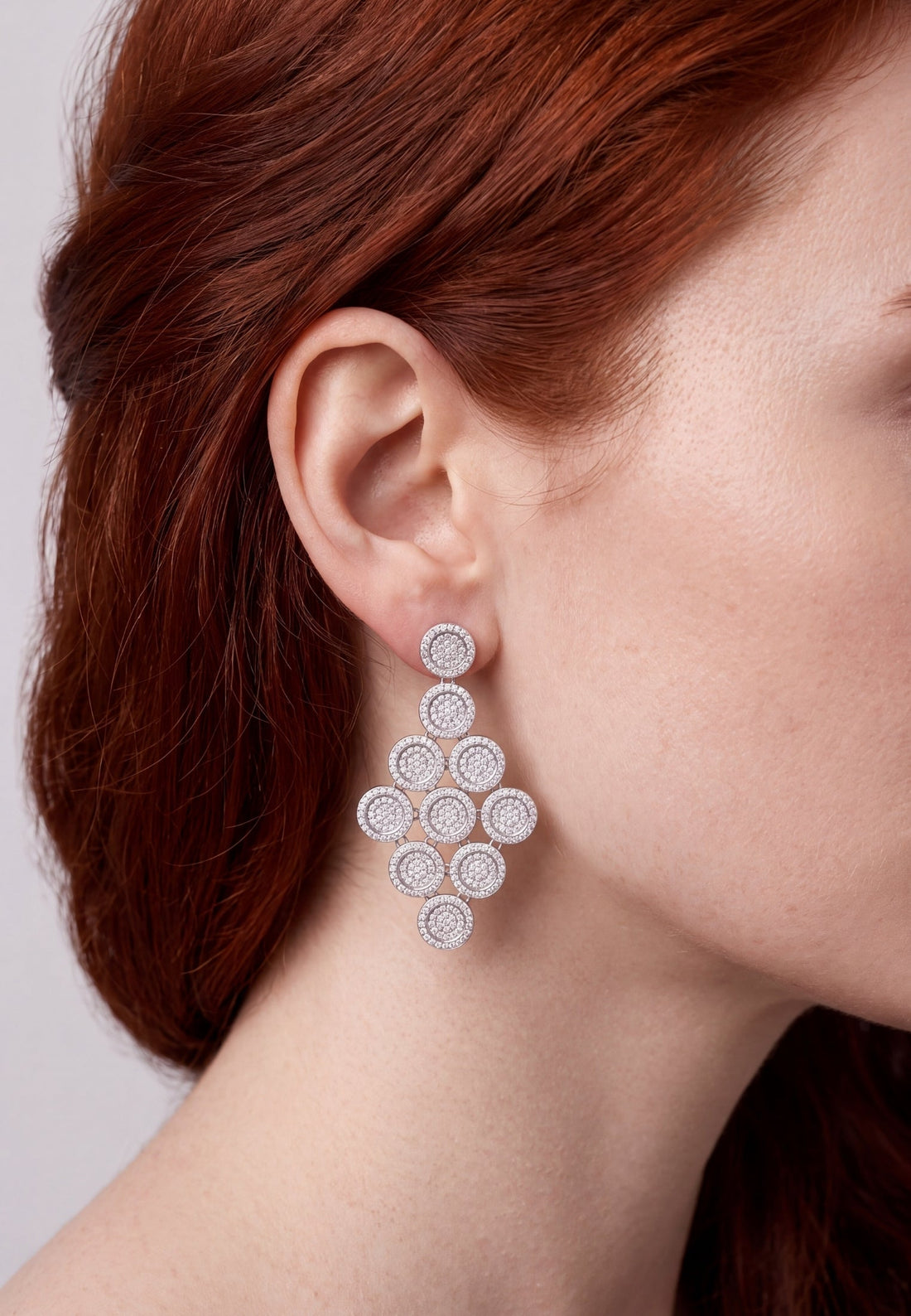 Silver disc cascading drop earring on ear