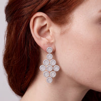 Silver disc cascading drop earring on ear