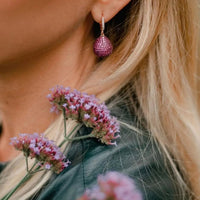 Gold pear drop gemstone earring with ruby-colored teardrop stone