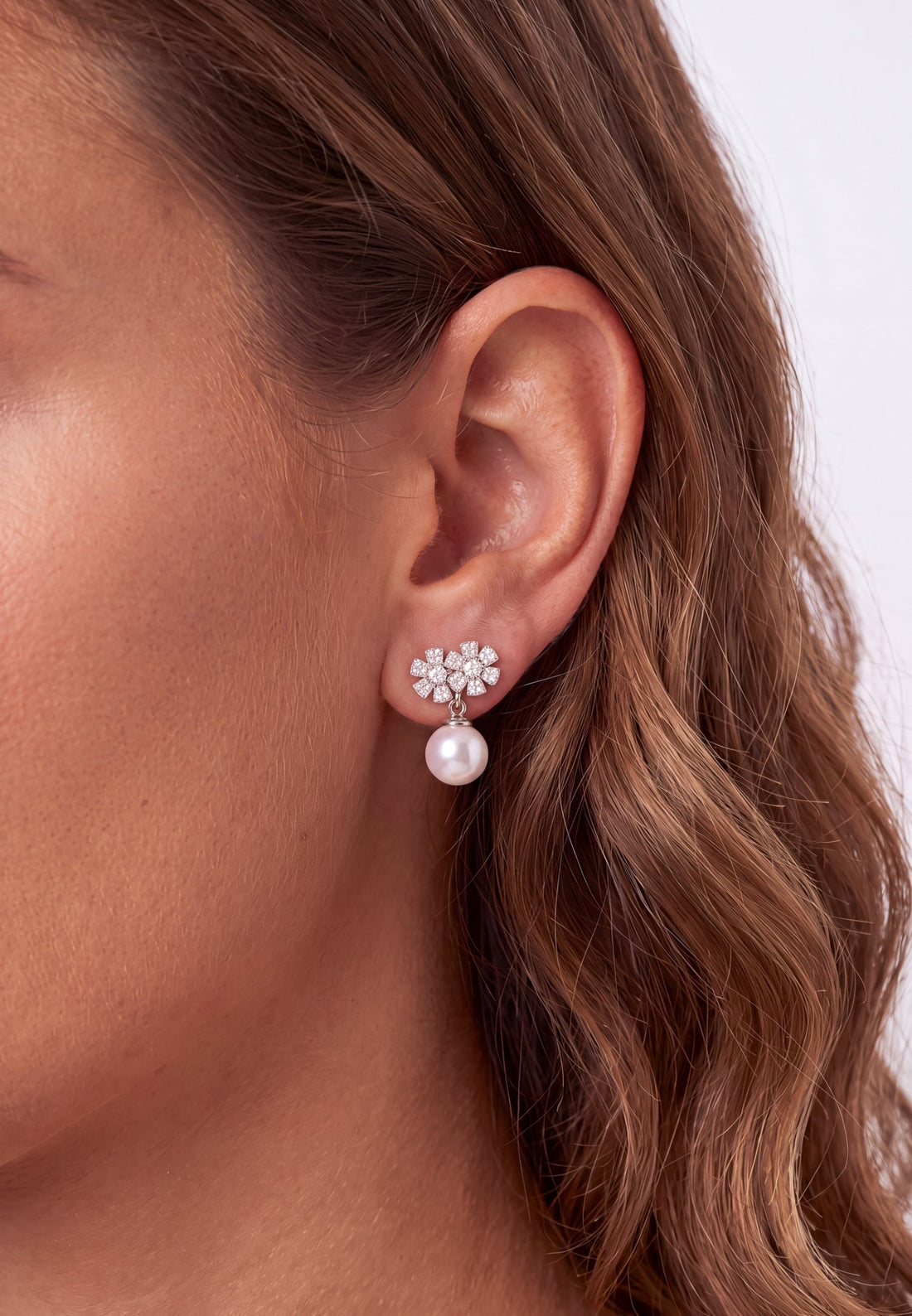 Floral crystal stud earrings with white pearl drop, silver tone
