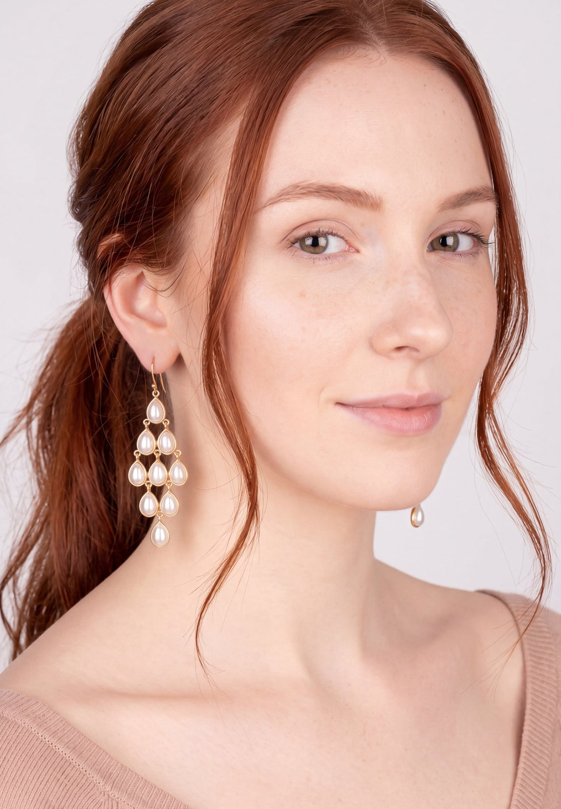 Pearl chandelier drop earrings with gold hooks, worn by model