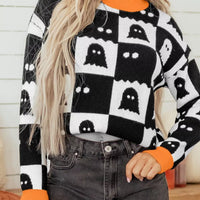 Black and white ghost checkerboard sweater with orange crew neck, cuffs, and hem
