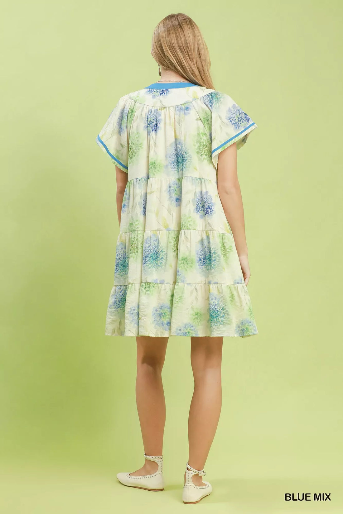 Floral babydoll dress back view, blue-trimmed cap sleeves and tiered skirt
