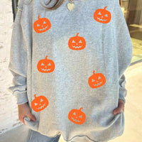 Light gray sweatshirt with orange pumpkin face motif all over
