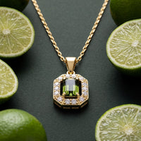 Gold gemstone pendant necklace with peridot-green rectangular center and crystal halo