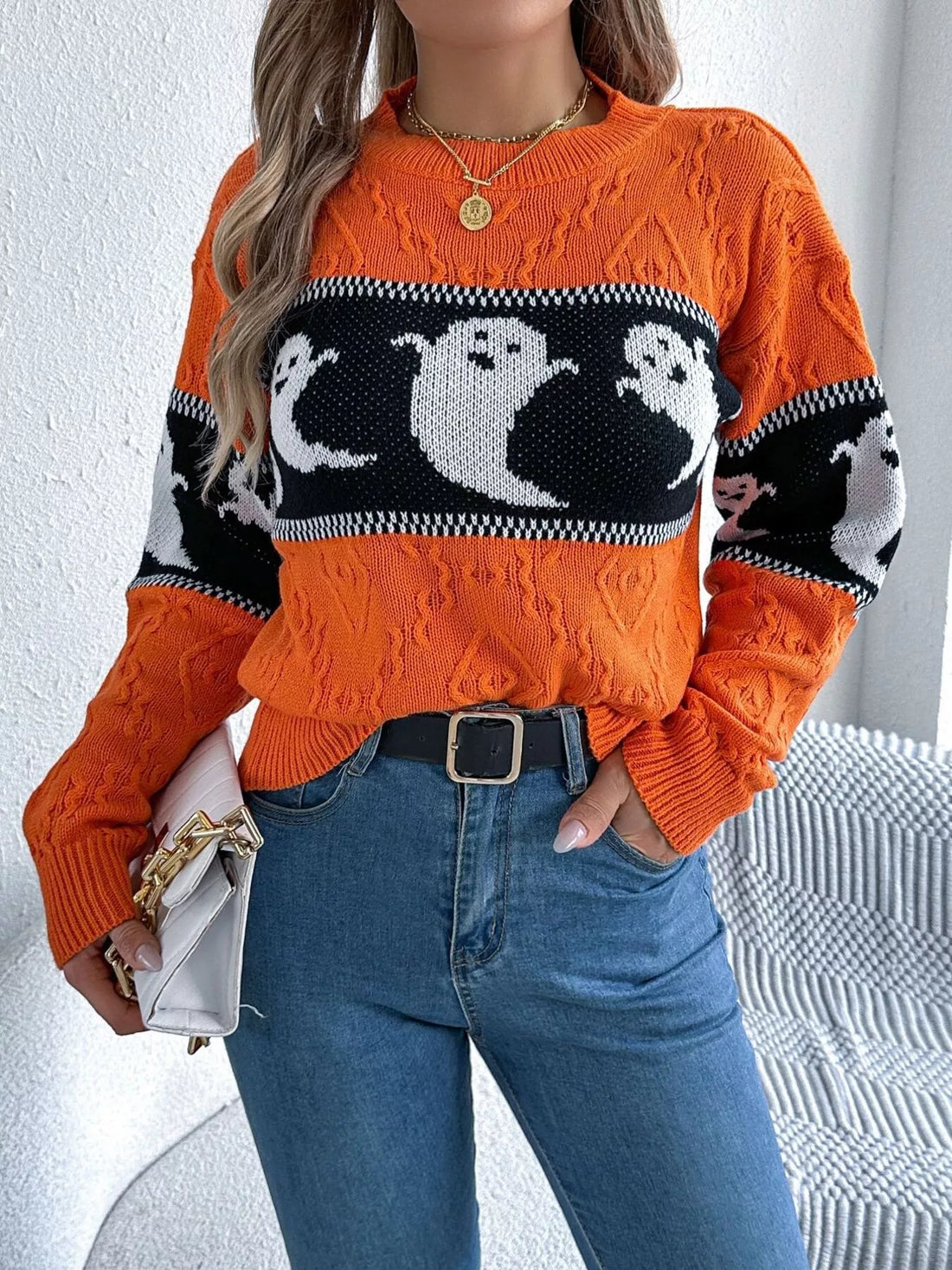 Orange textured sweater featuring a black-and-white ghost pattern and ribbed hem