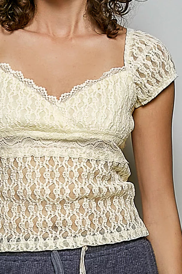 Natural lace short-sleeve top close-up with sweetheart neckline and floral pattern