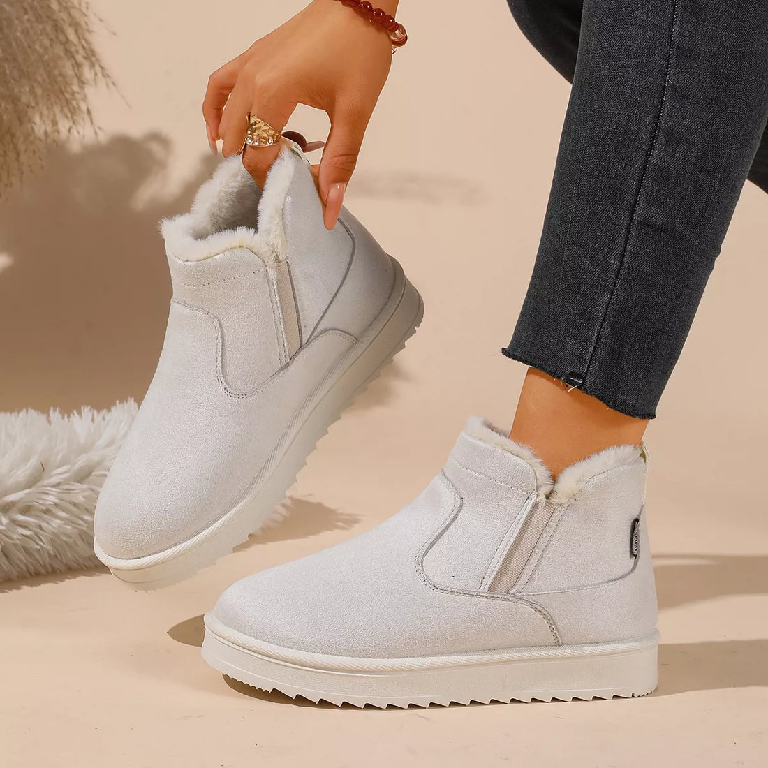 White plush-lined ankle boots with chunky rubber sole and pull-on style