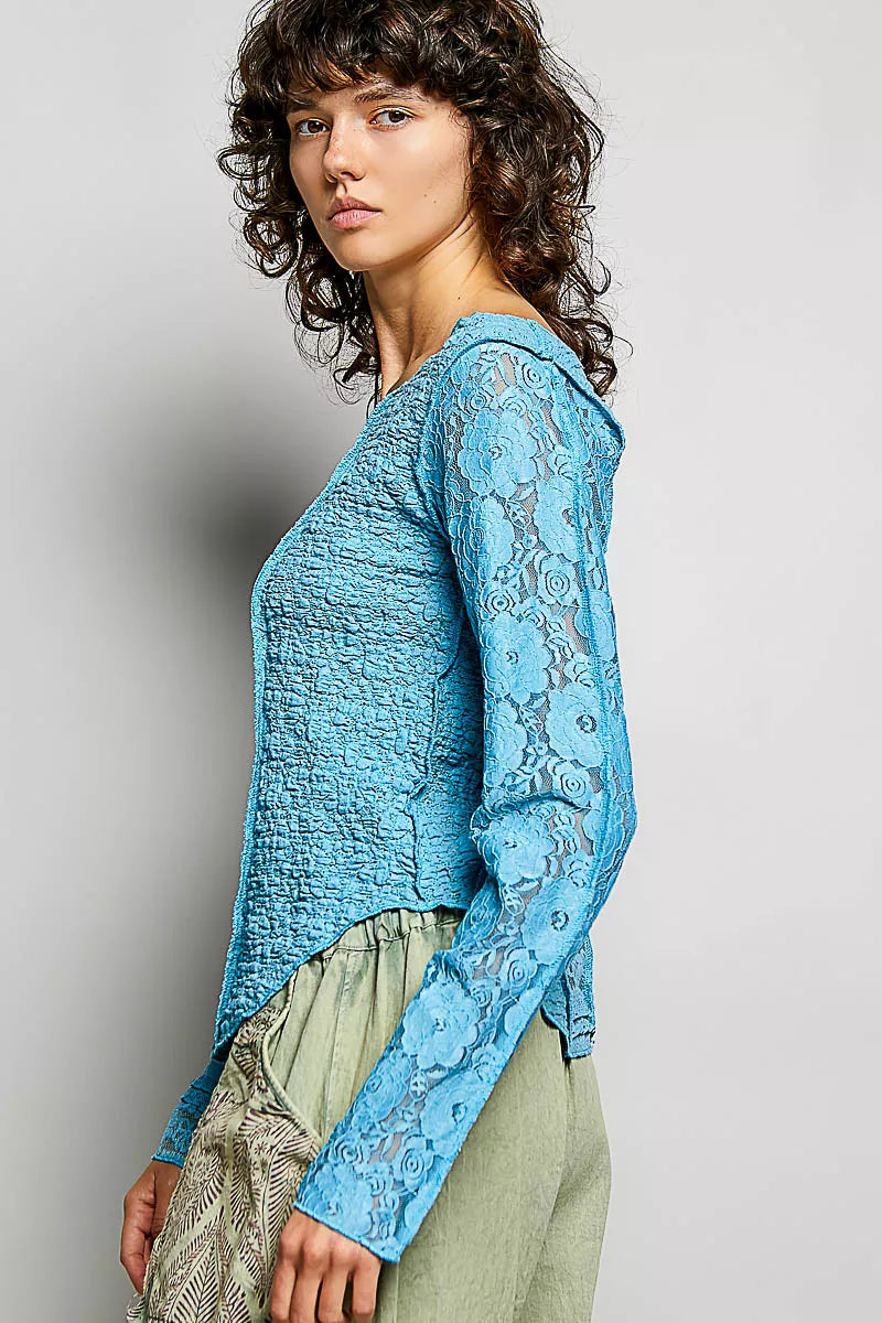 Teal blue lace long-sleeve top with round neck and exposed seams, side view