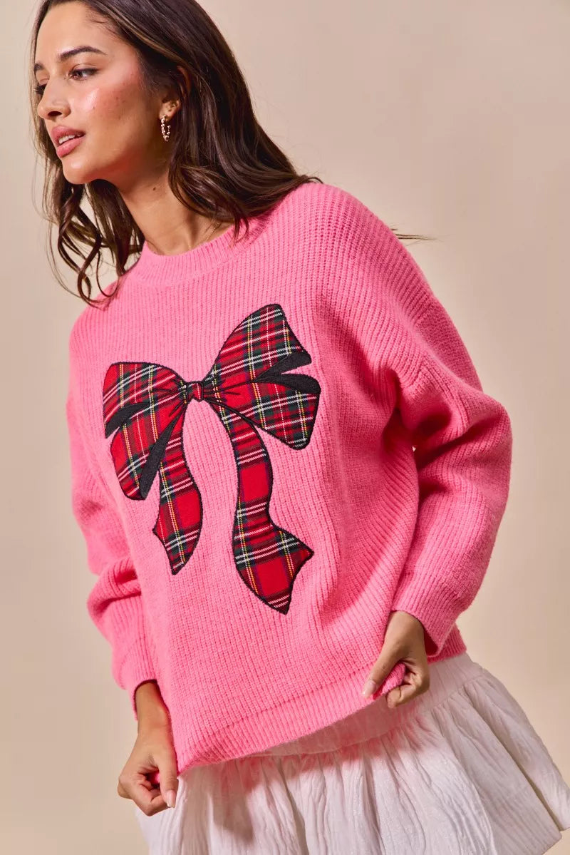Pink sweater with plaid ribbon bow detail and ribbed cuffs