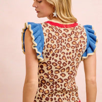 Leopard print knit top with blue ruffled sleeves and ribbed red hem