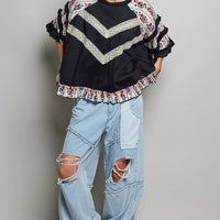Black contrast lace knit top with floral ruffle sleeves and hem, round neckline
