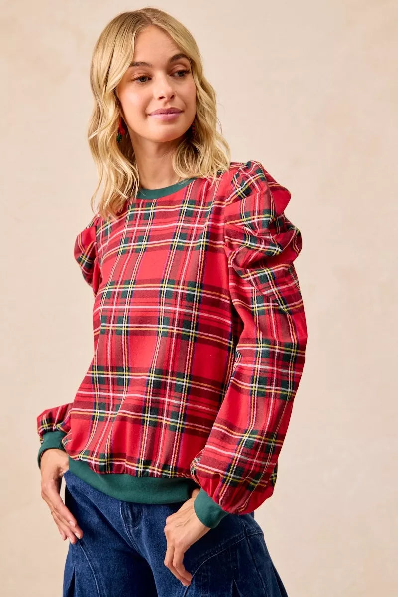 Red plaid top with exaggerated sleeves, green crew neckline, and cuffed hem