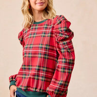 Red plaid top with exaggerated sleeves, green crew neckline, and cuffed hem