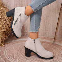 Beige suede ankle boots with round toe, block heel, and side zipper closure
