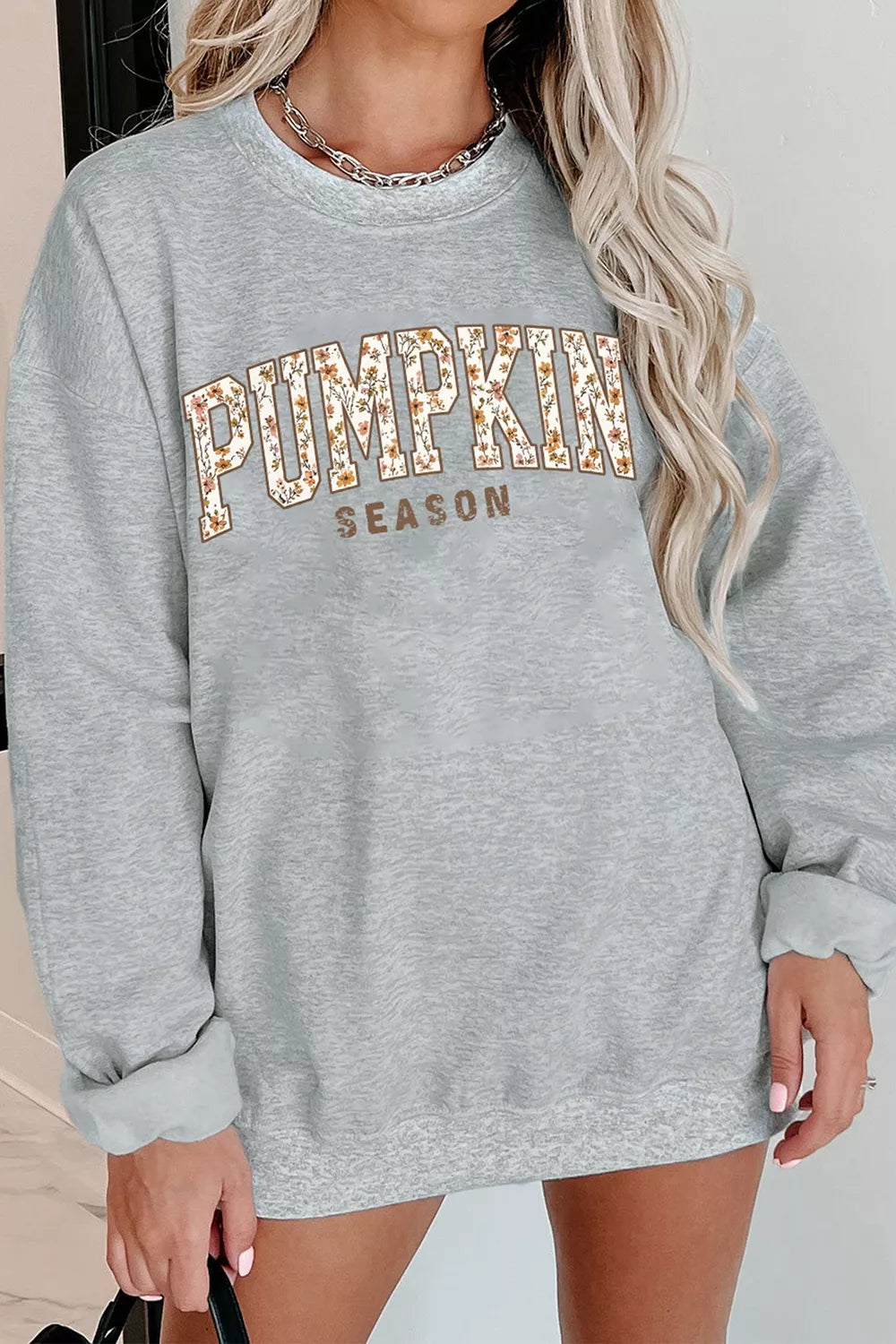 Gray oversized pullover sweatshirt with “PUMPKIN SEASON” graphic print at center front