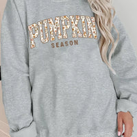 Gray oversized pullover sweatshirt with “PUMPKIN SEASON” graphic print at center front