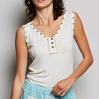Cream button-front tank with studded trim and ruffle placket detail