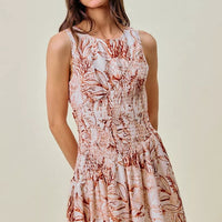 Front view: smocked coral and white shell-print mini dress, sleeveless with round neckline