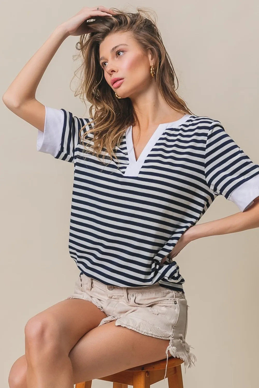 Contrast striped notched knit top, navy and ivory V-neck with short sleeves and side-twist hem.