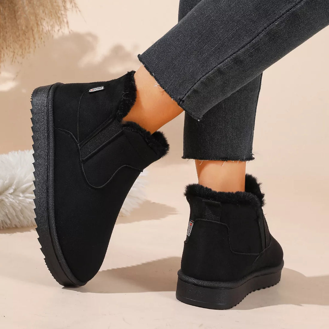 Black plush-lined ankle boots with fur trim and rear pull tab on chunky sole