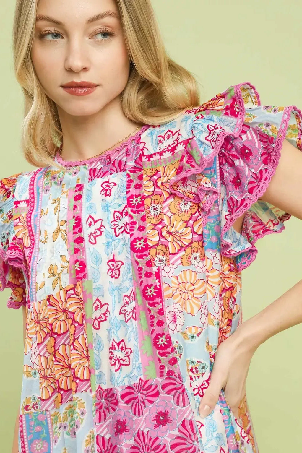 Close-up of pink patchwork mini dress with flutter sleeves and floral print