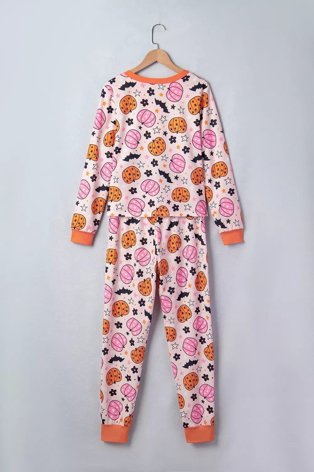 Dusty pink pumpkin-print pajama set with long sleeves and orange-trim cuffs