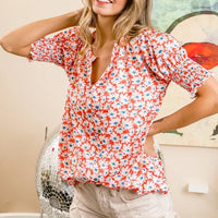Orange floral V-neck top with smocked puff sleeves and relaxed, gathered fit