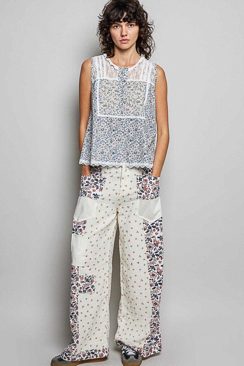 Off-white sleeveless lace round-neck top with blue floral print and scalloped edges
