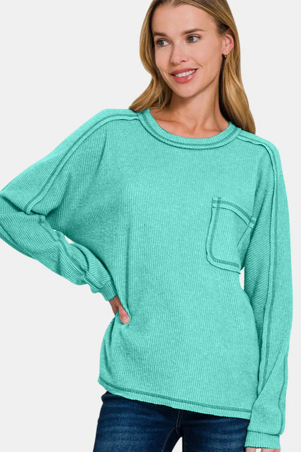 Turquoise knit top with contrast stitching on chest pocket and ribbed crew neck