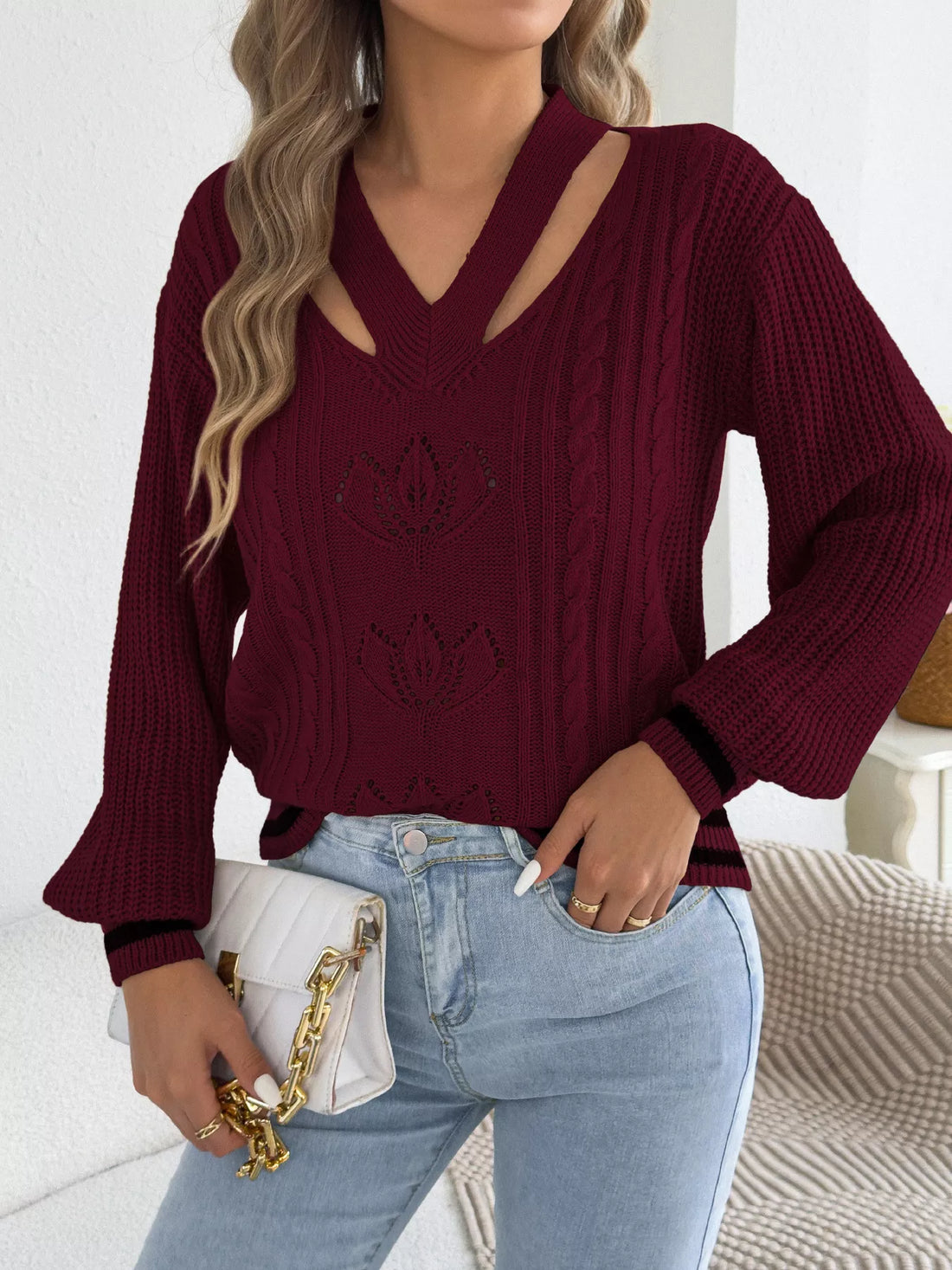 Burgundy cutout cable knit sweater with V-neck cutout and three lotus-style knit motifs