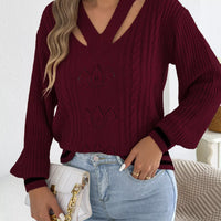 Burgundy cutout cable knit sweater with V-neck cutout and three lotus-style knit motifs