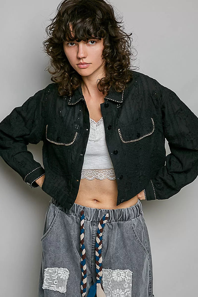 Black cropped button-front eyelet cotton jacket with pointed collar and front patch pockets.