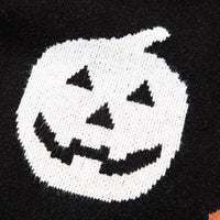 Black sweater close-up of large white jack-o-lantern face motif with orange accents