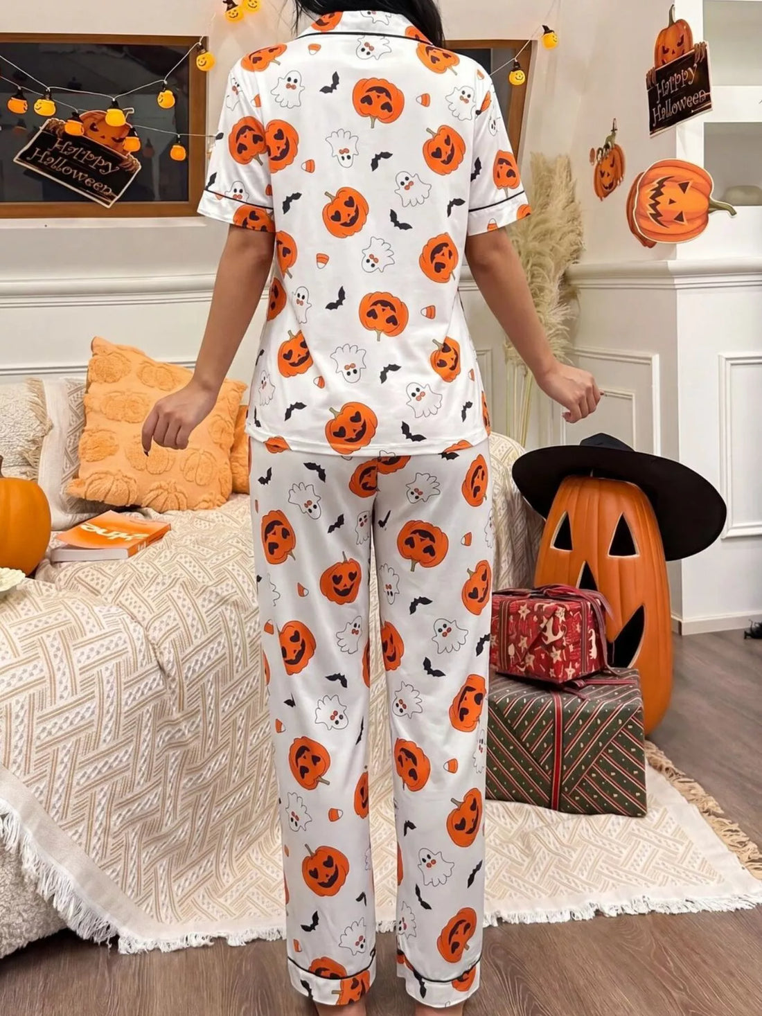 Halloween pajama set: white short-sleeve button-up top and matching pants with pumpkin prints