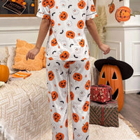 Halloween pajama set: white short-sleeve button-up top and matching pants with pumpkin prints