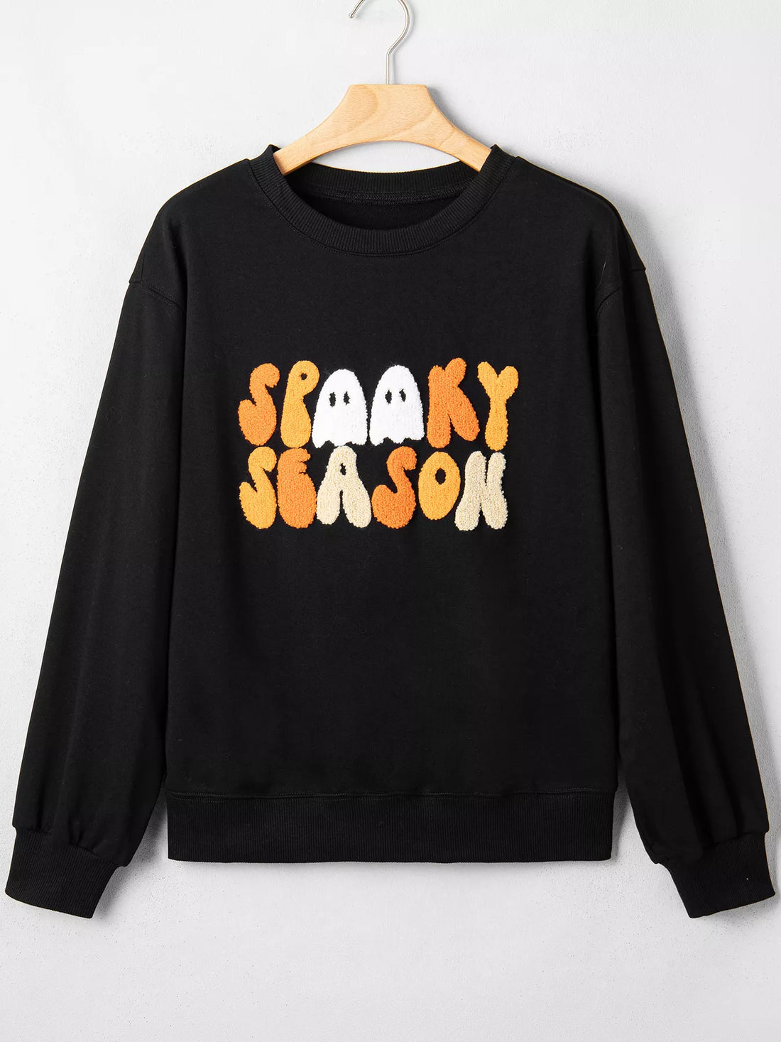 Black long-sleeve crewneck sweatshirt with embroidered “Spooky Season” graphic