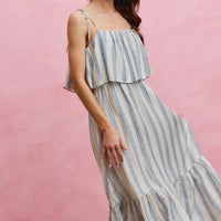 Side view of sleeveless striped midi dress with tiered ruffle hem and tie shoulder straps