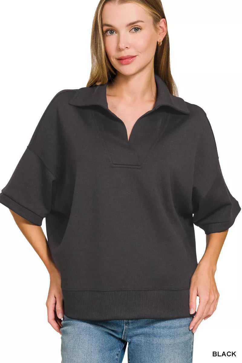 Black collared short-sleeve pullover with half-zip placket