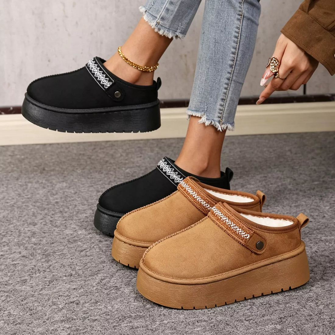 Black and camel suede fur-lined platform boots with chunky tread and patterned trim.