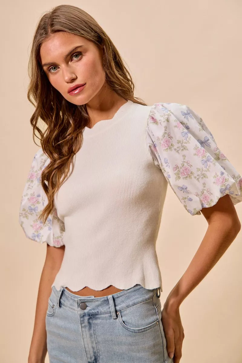 White ribbed sweater top with pastel floral contrast sleeves and scalloped hem