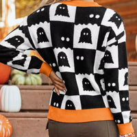 Side view of ghost checkerboard sweater in black and white with orange ribbed trim