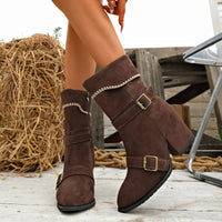Brown suede point-toe boots with block heels, buckled straps, decorative stitched trim.