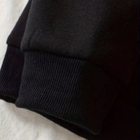 Black hoodie sleeve cuff and hem detail with ribbed knit finish