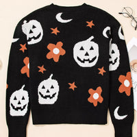 Black long-sleeve crewneck sweater with Halloween jack-o-lanterns, moons, stars, and orange blooms
